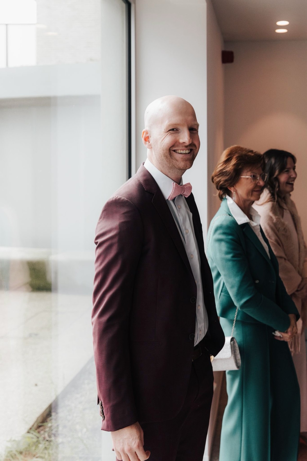Candid photo of Simon Dhaenens in a burgundy suit at an event.